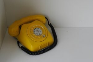 A yellow telephone sitting on top of a white counter